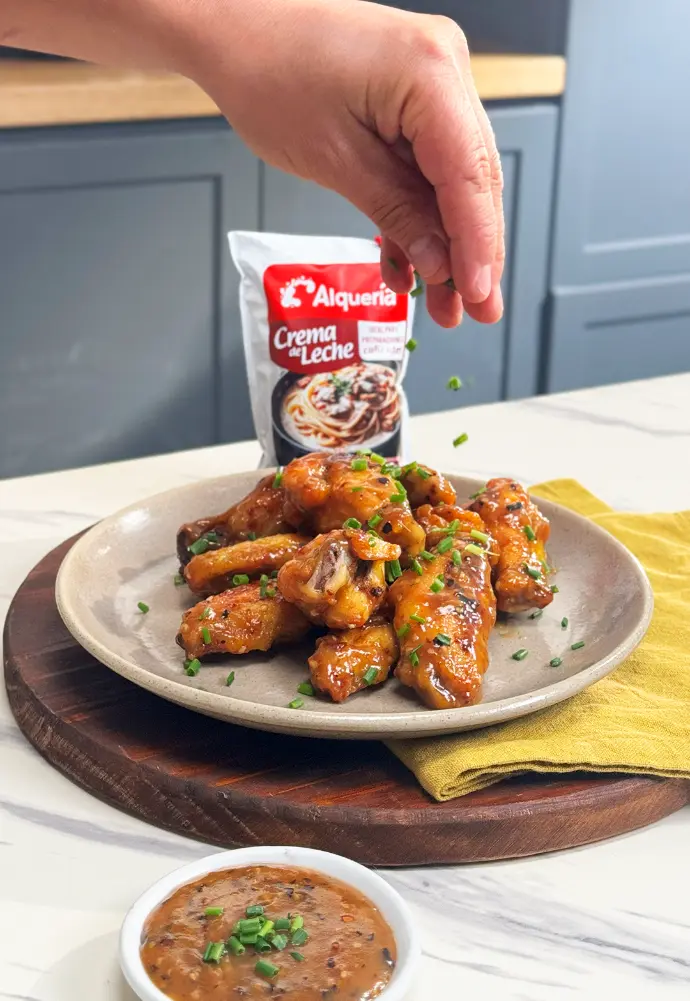 Plato gourmet decorado con crema Alquería en presentación elegante.